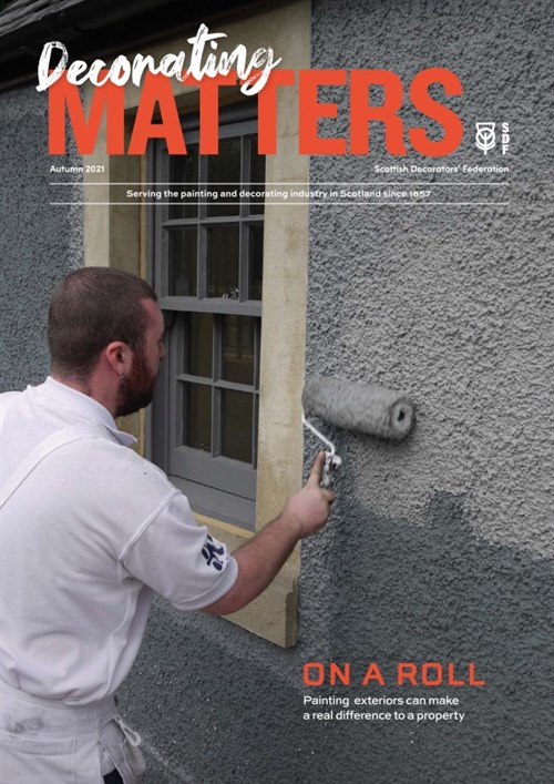 Cover, Decorating Matters Autumn 2021. A decorator applies grey paint to an external wall with a roller